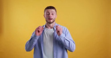  Sarı arka plandaki mutlu sakallı genç adam.