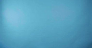  Açık mavi arka planda beliren mutlu genç adam