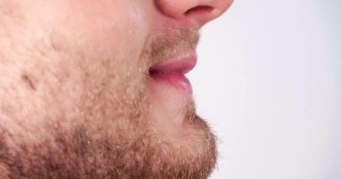  Genç sakallı adam arka planda gülümsüyor, profil görüntüsü yakın.