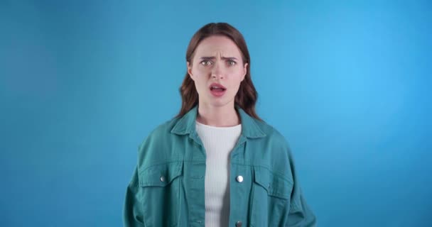 ライトブルーの背景で不快なオファーを拒否する若い女性 — ストック動画
