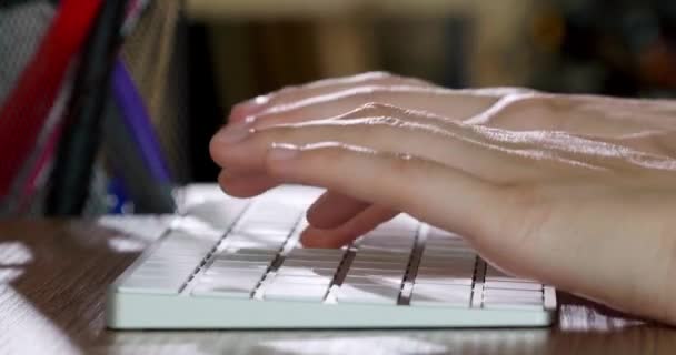屋内の木のテーブルのコンピュータ キーボードでタイピングする女性の手 クローズアップ — ストック動画