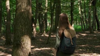 Doğayla birlik. Ormanda yürüyen ve ağaca dokunan kadını izleyen kamera.
