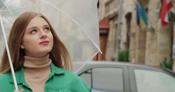 街を歩いている透明な傘を持つ若い美しい女性 — ストック動画