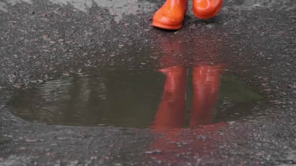 Vrouw Fel Oranje Regen Laarzen Lopen Door Plas Buiten Close — Stockvideo