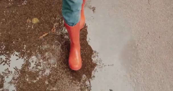 Kvinna Ljusa Orange Regnstövlar Går Genom Pölar Utomhus Ovanför Närbild — Stockvideo