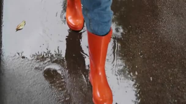 Frau Leuchtend Orangefarbenen Regenstiefeln Die Draußen Durch Pfützen Laufen Über — Stockvideo