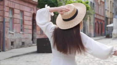 Şehir sokaklarında şık ceketli ve şapkalı mutlu genç bir kadın