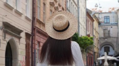 Şehir sokaklarında şık ceketli ve şapkalı mutlu genç bir kadın