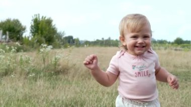 Tarlada yürüyen sevimli küçük kız, kameralar sağa doğru dönüyor.