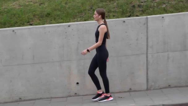Jonge Sportieve Vrouw Met Oortjes Lopen Rusten Het Lopen Buiten — Stockvideo