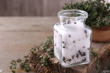 Cam kavanozda biberli tuz ve ahşap masada kekik, metin için boşluk.