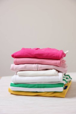 Bej arkaplana karşı katlanmış kıyafet yığını