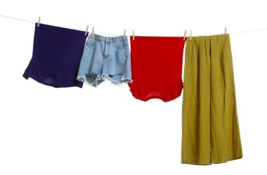 Different clothes drying on laundry line against white background