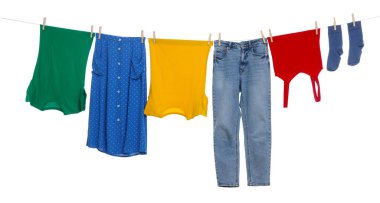 Different clothes drying on laundry line against white background