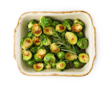 Lezzetli kavrulmuş Brüksel lahanası ve biberiye beyaz, üst manzara izole edilmiş fırın tabağında.