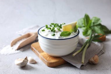 Tabakta yeşil soğanlı lezzetli yoğurt, sarımsak, tuz ve limon.