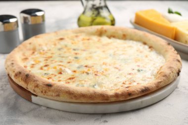 Işık masasında nefis peynirli pizza, yakın plan.