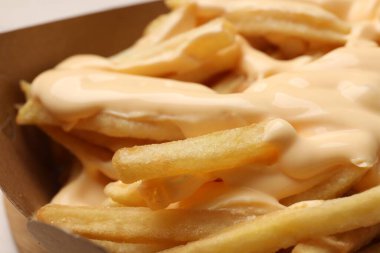 Lezzetli patates kızartmaları ve peynir sosu, kapta, yakın plan.