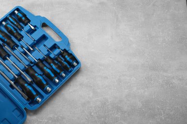 Gri desenli masadaki açık alet kutusunda tornavida seti, üst görünüm. Metin için boşluk