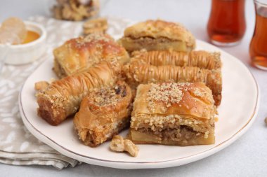 Doğu tatlıları. Lezzetli baklava parçaları beyaz masada, yakın plan.