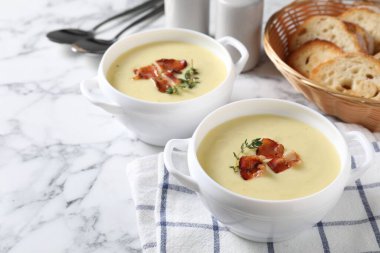 Pastırmalı patates çorbası ve beyaz mermer masada servis edilen biberiyeler.