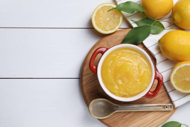 Lezzetli limonlu kase, taze narenciye meyveleri ve beyaz ahşap masa üzerinde kaşık, düz yatak. Metin için boşluk