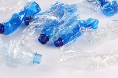 Kırışmış tek kullanımlık plastik şişeler beyaz arka planda