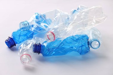 Kırışmış tek kullanımlık plastik şişeler beyaz arka planda
