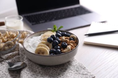 Lezzetli granola beyaz ahşap masada, yakın plan.