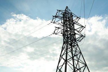 Telefon direği ve kablolar bulutlu mavi gökyüzüne karşı