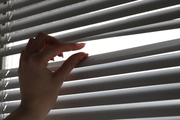 Женщина разделяет белые планки в помещении, крупным планом