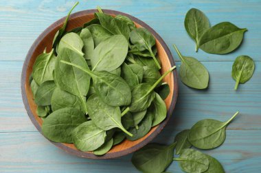 Taze ıspanak yaprakları açık mavi ahşap masada, düz yatıyordu.