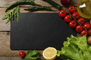 Yemek pişiriyorum. Siyah kesme tahtası ve ahşap masa üzerinde farklı ürünler, düz yatıyordu.