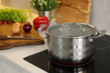 Yemek pişiriyorum. Mutfakta tencerenin üstünde.