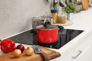 Yemek pişiriyorum. Mutfaktaki tezgahın üstünde taze sebze ve çömlek.