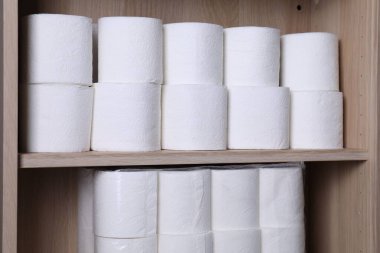 Tahta raflarda istiflenmiş tuvalet kağıdı ruloları