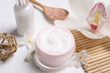 Beyaz masa üzerinde kozmetik ürünleri ve çiçekleri olan güzel bir spa kompozisyonu