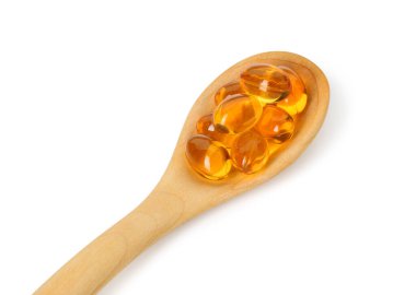 Beyaz kaşıkta izole edilmiş vitamin kapsülleri. Sağlık takviyesi