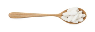 Tahta kaşıkta vitamin hapları, beyazın üstünde izole edilmiş. Sağlık takviyesi