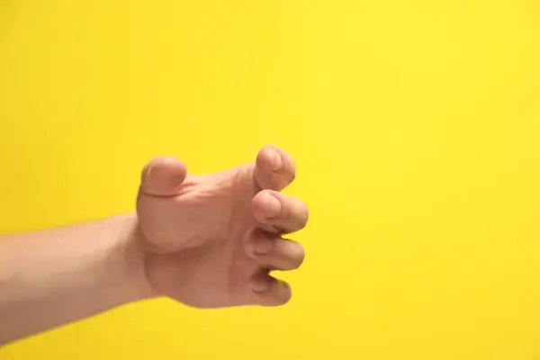 Man Met Iets Hand Gele Achtergrond Close Ruimte Voor Tekst — Stockfoto
