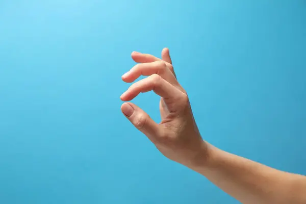 Kvinna Som Håller Något Handen Ljusblå Bakgrund Närbild — Stockfoto