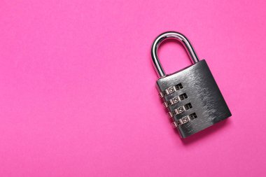 Pembe arka planda bir çelik kombinasyon asma kilit, üst manzara. Metin için boşluk
