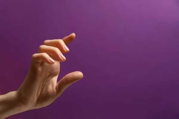 Vrouw Met Iets Hand Paarse Achtergrond Close Ruimte Voor Tekst — Stockfoto