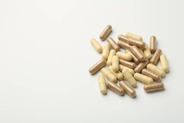 Beyaz arka planda farklı vitamin kapsülleri. Metin için boşluk