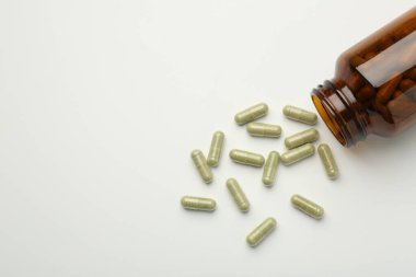 Beyaz arka planda şişe ve vitamin kapsülleri düz. Metin için boşluk