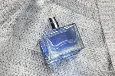 Şatafatlı erkek parfümü şişede, gri ceketin üstünde, yukarıda.