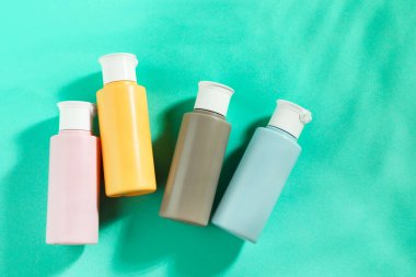 Turkuaz arka planda kozmetik seyahat seti, üst manzara. Metin için boşluk