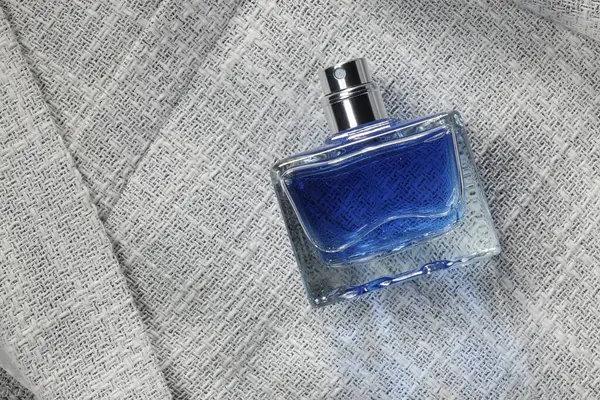 华丽男人的香水在瓶子灰色夹克 顶部视图 案文的篇幅 — 图库照片