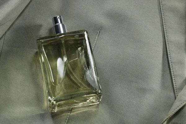 华丽男人的香水在瓶子上灰色夹克 俯瞰上方 案文的篇幅 — 图库照片