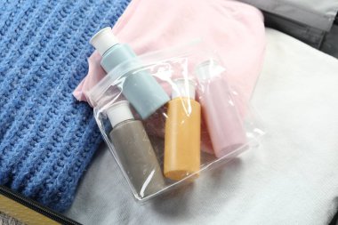 Çantanın içinde plastik kozmetik seyahat seti var.